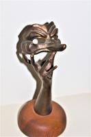 A bronze masquerade theatrical mask being held by a hand (9 of 9) A bronze masquerade theatrical mask being held by a hand (9 of 9)
